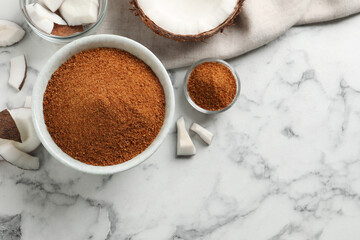 Flat lay composition with natural coconut sugar on white marble table, space for text