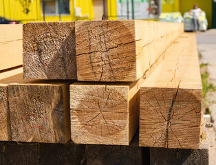a stack of wooden balks, wooden balks, beams at a sawmill, a warehouse of beams on the site of a building materials store. Wood, timber, wood beams, construction material