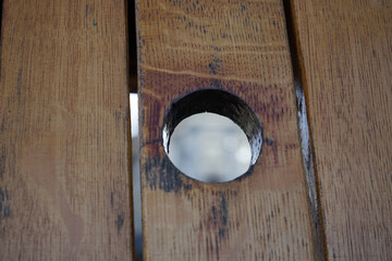 A round hole in a wooden slate