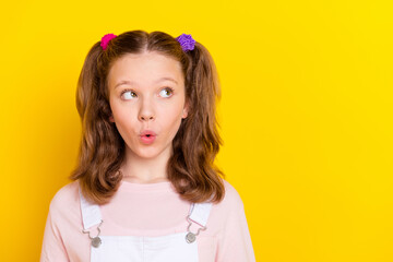 Photo portrait schoolgirl amazed in casual overall looking copyspace isolated bright yellow color...
