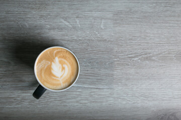 Hot coffee cup of latte art, coffee on wooden table in the morning. Top view