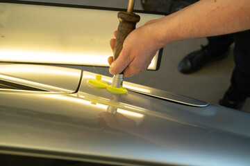 Process Of Paintless Dent Repair On Car Body. Technician s Hands With Puller Fixing Dent On Rear Car Fender. PDR Removal Course Training - obrazy, fototapety, plakaty