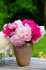 A bouquet of pink and white peony flowers in a vase