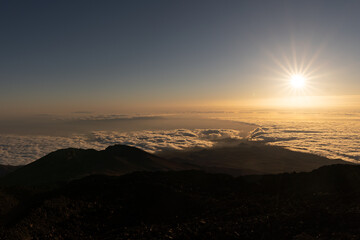 Sunset view from el Teide volcano, Tenerife canary island Spain. Silhouette people. Sun above clouds	