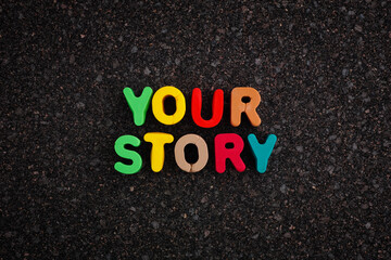 The phrase Your Story on a dark cork board