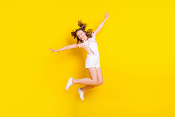 Fototapeta na wymiar Full length body size view of attractive funky cheerful girl jumping having fun good mood isolated over bright yellow color background