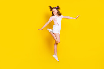 Fototapeta na wymiar Full length body size view of attractive girlish cheerful girl jumping posing good mood isolated over bright yellow color background