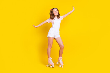 Fototapeta na wymiar Full length body size photo schoolgirl dancing wearing rollers isolated bright yellow color background