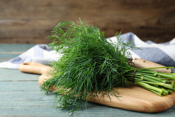 Bunch of fresh dill on light blue wooden table - Powered by Adobe
