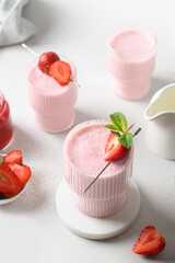Strawberry lassi or milkshake on a white background with copy space. Close up. Healthy ayurveda dairy beverage of strawberries for special dosha.