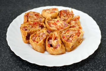 Obraz na płótnie Canvas Puff pastry rolls stuffed with ham and red pepper