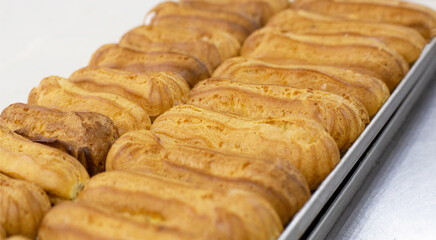 Fresh custard eclairs cakes lie on the table, background, pastry, handmade