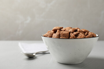 Sweet crispy corn pads in bowl and spoon on light table