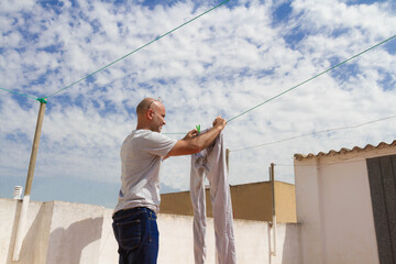 Spanish housekeeper laying the laundry on the roof of a house