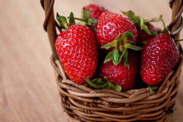 Wicker basket fulled with ripe strawberries close up