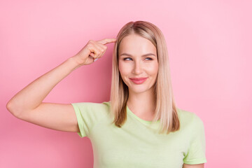 Photo of minded cunning lady finger head tricky look side empty space wear green t-shirt isolated...