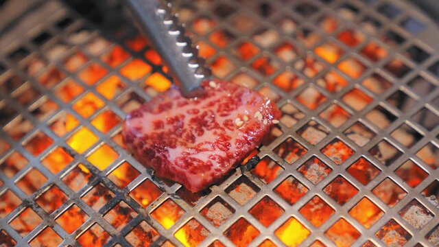 Slow motion 4K. Charcoal stove for grilling meat, seafood. There is a system to absorb odors and smoke in Korean restaurants. Korean style grill food