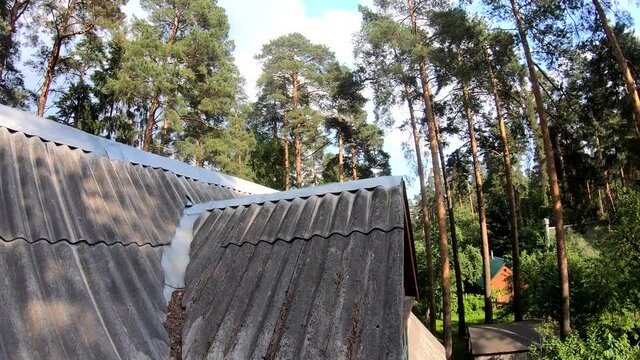 the racing drone rises above the roof of the house and flies around the garden in first-person view on-board camera