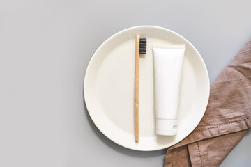 Ecology toothbrush on grey background. Brush on plate. Breakfast concept. Sustainable mouth...