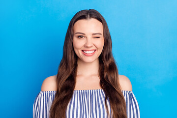 Photo of charming shiny young woman dressed striped outfit smiling winking isolated blue color...