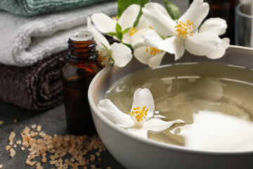 Fototapeta na wymiar Beautiful spa composition with jasmine essential oil and fresh flowers on grey table, closeup