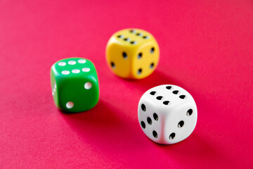 Three colorful dices isolated on pink background