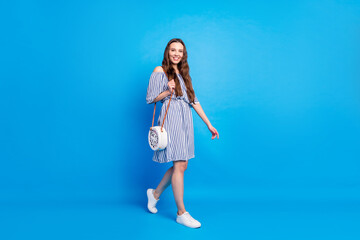 Full body photo of charming attractive young woman walk empty space isolated on pastel blue color background