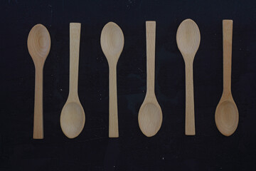 empty wooden spoons on a black background, top view, set