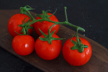 Cherry tomatoes isolated on a black background. Close-up. Copy space.