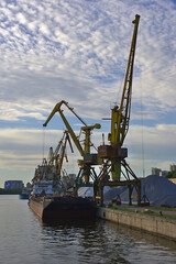 Fototapeta na wymiar crane in the port at the loading of a barge