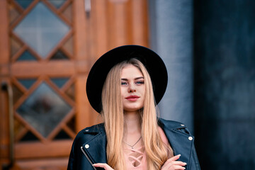Young beautiful blonde in a black hat. Banner with copy space