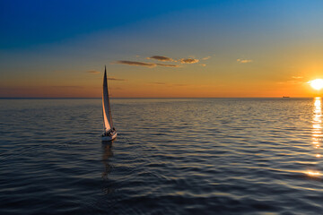Riga, Latvia 12-06-2021 Yacht sailing against sunset. Holiday lifestyle landscape with skyline...
