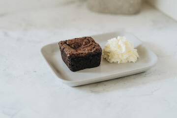 Brownie with whipped cream on a plate