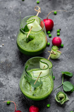 Two green smoothie with green fresh peas, cucumber, radish, spinach and lime. vertical image. top view