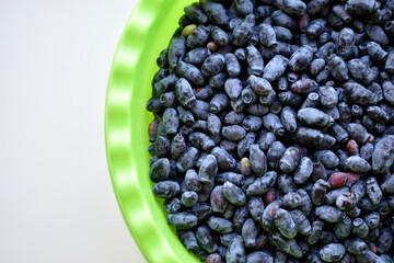 Blue fresh honeysuckle berries in a green pot
