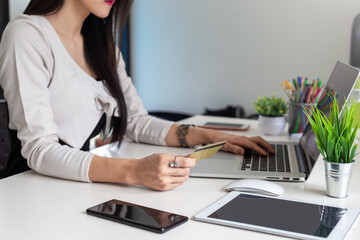 Businesswoman hand holding credit card using laptop online shopping.