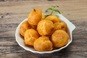Sweet tasty profiteroles heap in the bowl