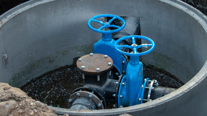 two blue valves for supplying water to a sewer well