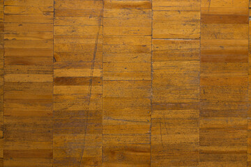 Pattern old light brown lacquered wooden parquet, background with scuffs, scratches and cracks