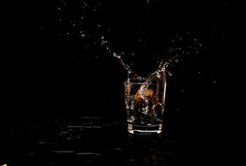 High resolution water splash motion from a clean glass of water kept on a wooden serving tray