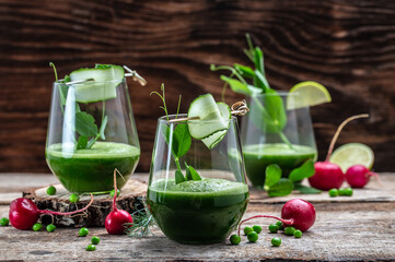 Glass of Fresh Green Smoothie with Organic Greens and Limes, Detox smoothie, green fresh peas, cucumber, spinach and lime. Healthy Detox Drink