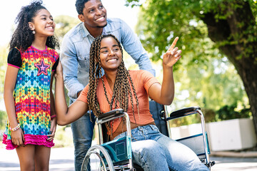 Woman in a wheelchair enjoying a walk outdoors with family.