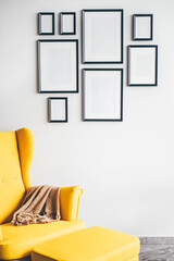 Multiple many black picture frames on white wall.