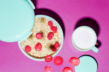 Bowl with cereal berries and cup of milk