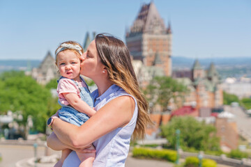 women with baby at the blurred Frontenac Castle in the background