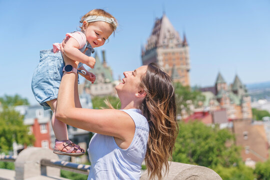 women with baby at the blurred Frontenac Castle in the background