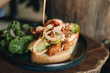 Toast with crispy fried spicy chicken, onion and sause