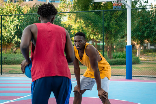 Two young African American men playing basketball.