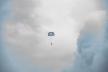 Parachutist descends by parachute / paratrooper /
