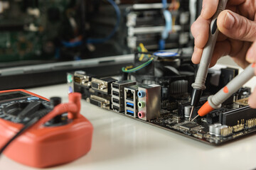 A technician checks the serviceability of the computer motherboard.